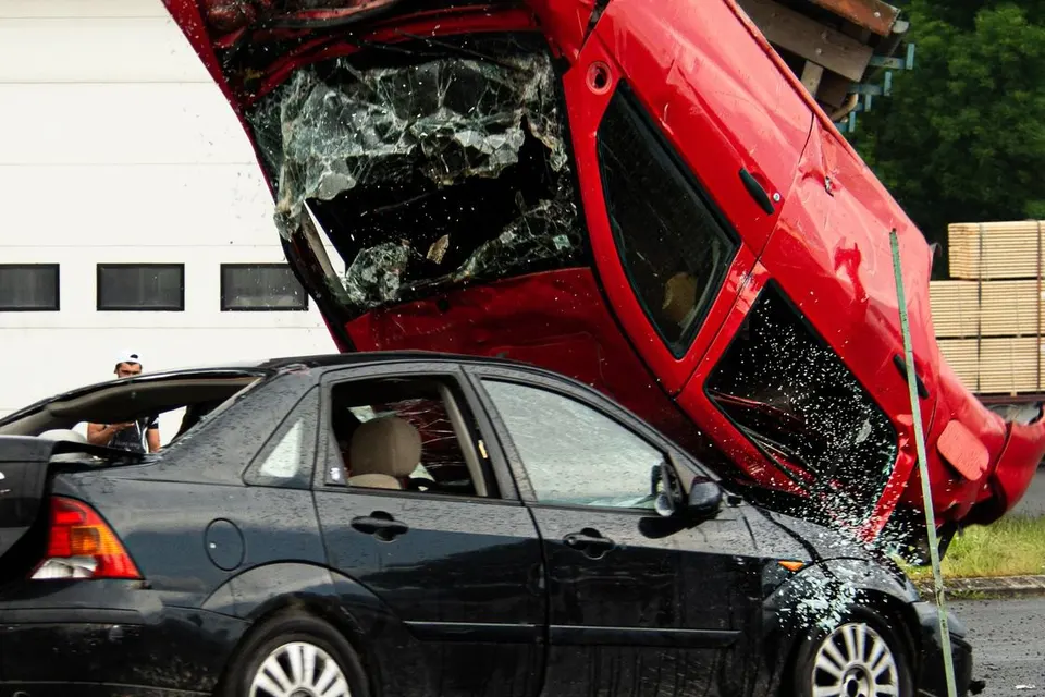 Two cars after a collision on a street, one lifted onto the other