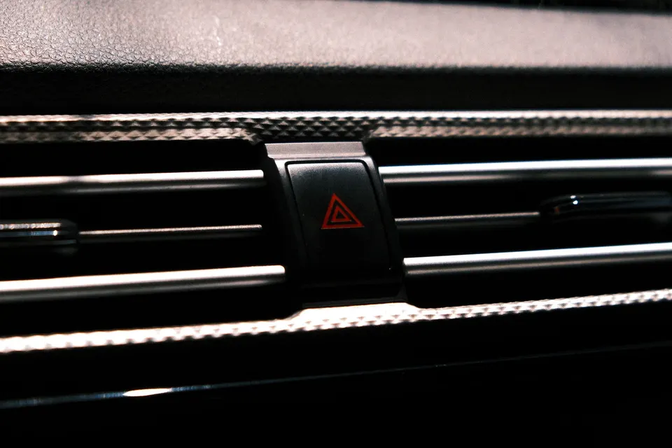 The red hazard warning light button on a car dashboard