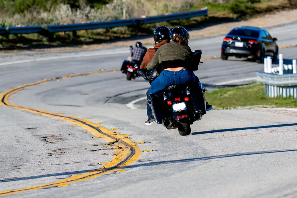 Two motorcycles riding through a curve on a two-lane American road