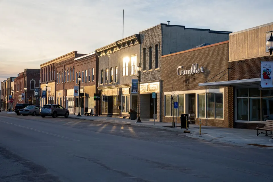 A small-town main street lined with brick storefronts at sunset