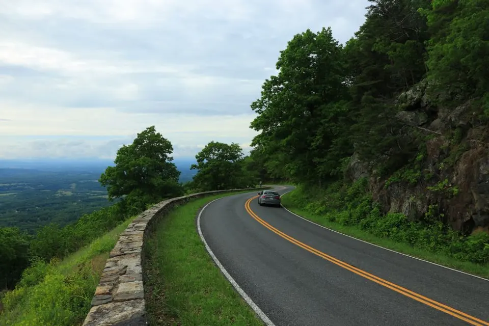 A winding two-lane Virginia parkway road with a single car on it